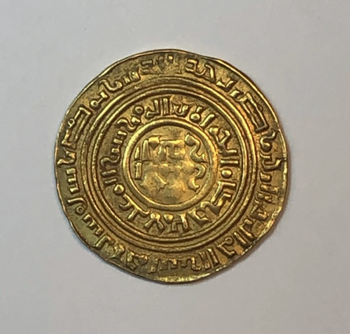 Figure 12.2. The reverse of a gold coin with a center image and two pseudo-Arabic inscriptions encircling the coin’s center and edge.