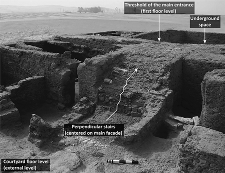 Figure 3.9. An image of courtyard ruins with perpendicular staircase and main staircase, with courtyard floor level and underground space labeled with arrows.