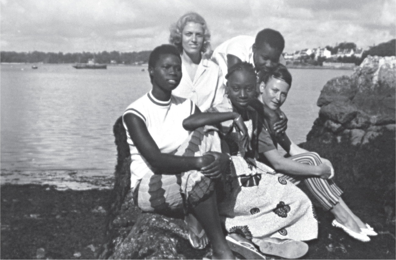 Five French and African young women and girls pose together on the Brittany coast in 1960.