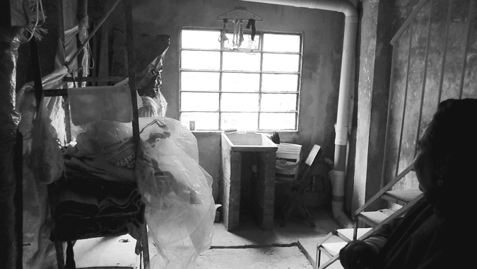 Figure 6.6. An interior unfinished and unfurnished room, with a woman in shadow, looking at the room from the right side of the frame.