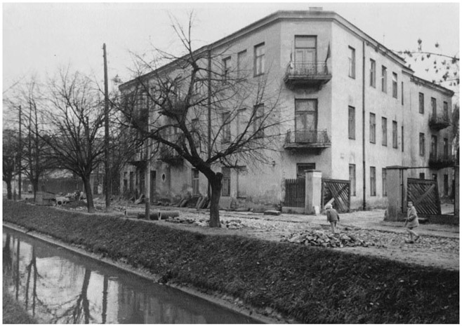 Figure 24. Exterior of a building behind trees and a small creek.
