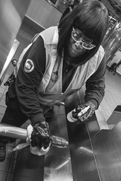 Figure 2. An unmasked transit worker scrubs a subway turnstile in the early weeks of the pandemic, when the COVID-19 virus was mistakenly believed to spread on surfaces more easily than it spread through the air.