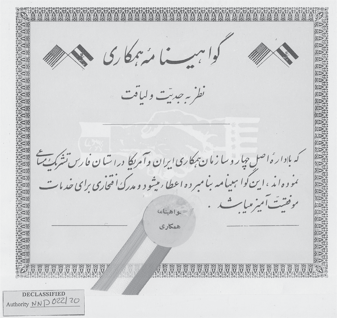 The certificate features the flags of the United States and Imperial Iran in the two upper corners; a gold seal with a red, white, and green ribbon on the bottom; and two shaking hands in the middle. It symbolizes “friendship” between the United States and Iran during the Cold War.
