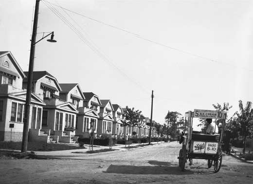 Figure 7.7. A 1920s photograph shows a row of modest townhouses in Sheepshead Bay. An ice cream wagon approaches from the right foreground.