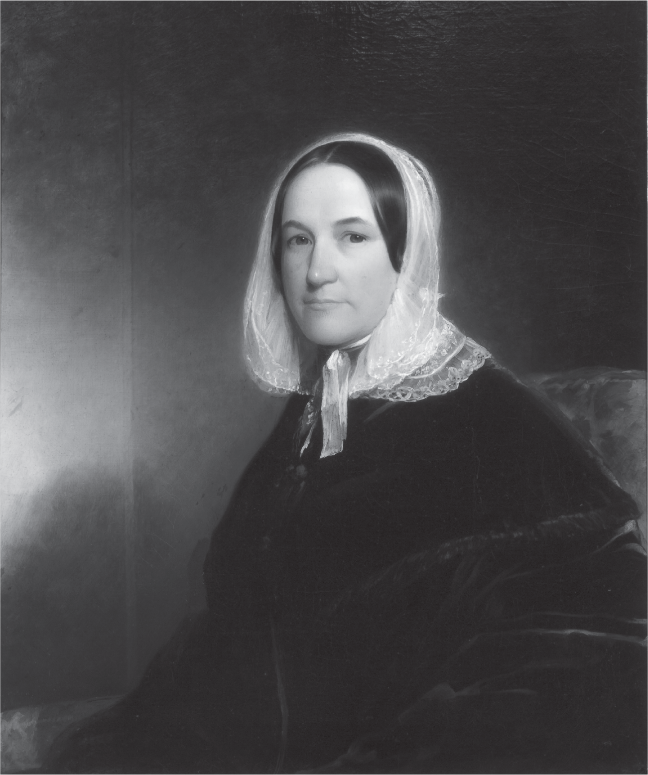 A seated woman looks ahead, with an intentionally modest gaze. She is cloaked to the neck in a dark heavy garment. She wears a white lace bonnet that covers much of her straight black hair.