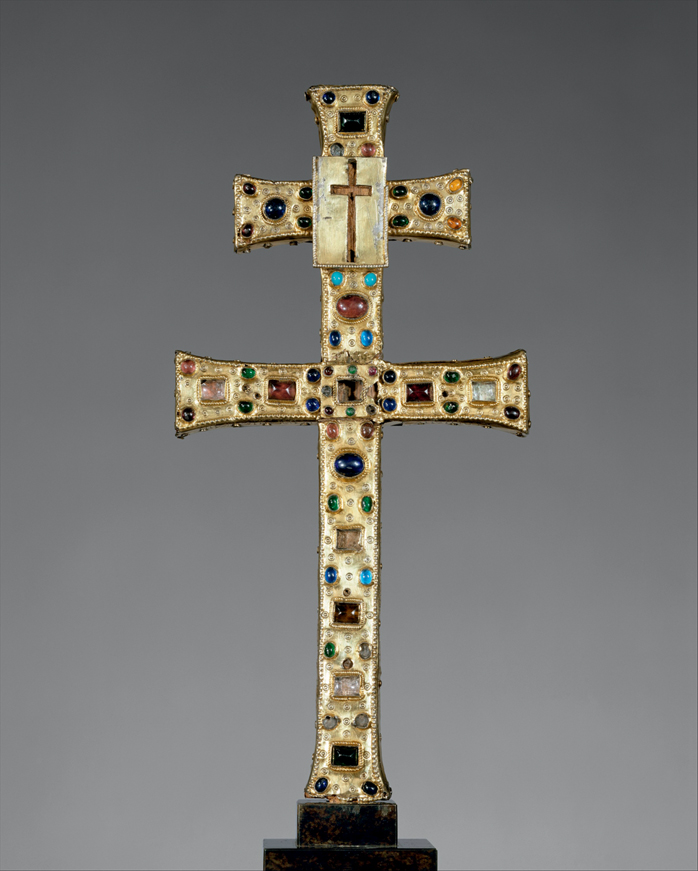 Figure 28. A gold, bejeweled cross with two cross-bars, the top smaller than the bottom, and a small plaque with a cut-out cross placed at the intersection of the top crossbar.