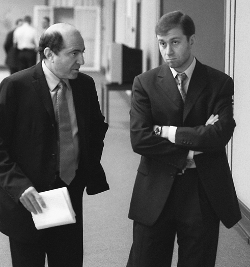 Boris Berezovsky talking with Roman Abramovich, whose arms are folded, June 2000.