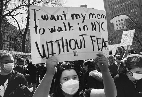 Figure 23. A young Asian woman in a crowd raises a sign saying, “I want my mom to walk in NYC without fear.”