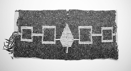 Shell bead wampum belt with two white squares on each end and a white tree in the center. The white figures are over a background of purple beads. The squares and tree represent the Five Nations of the Iroquois Confederacy.