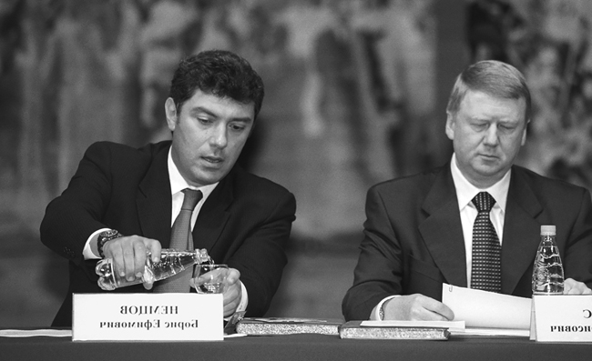 Boris Nemtsov and Anatoly Chubais sitting together at a speaker’s platform, 1999.