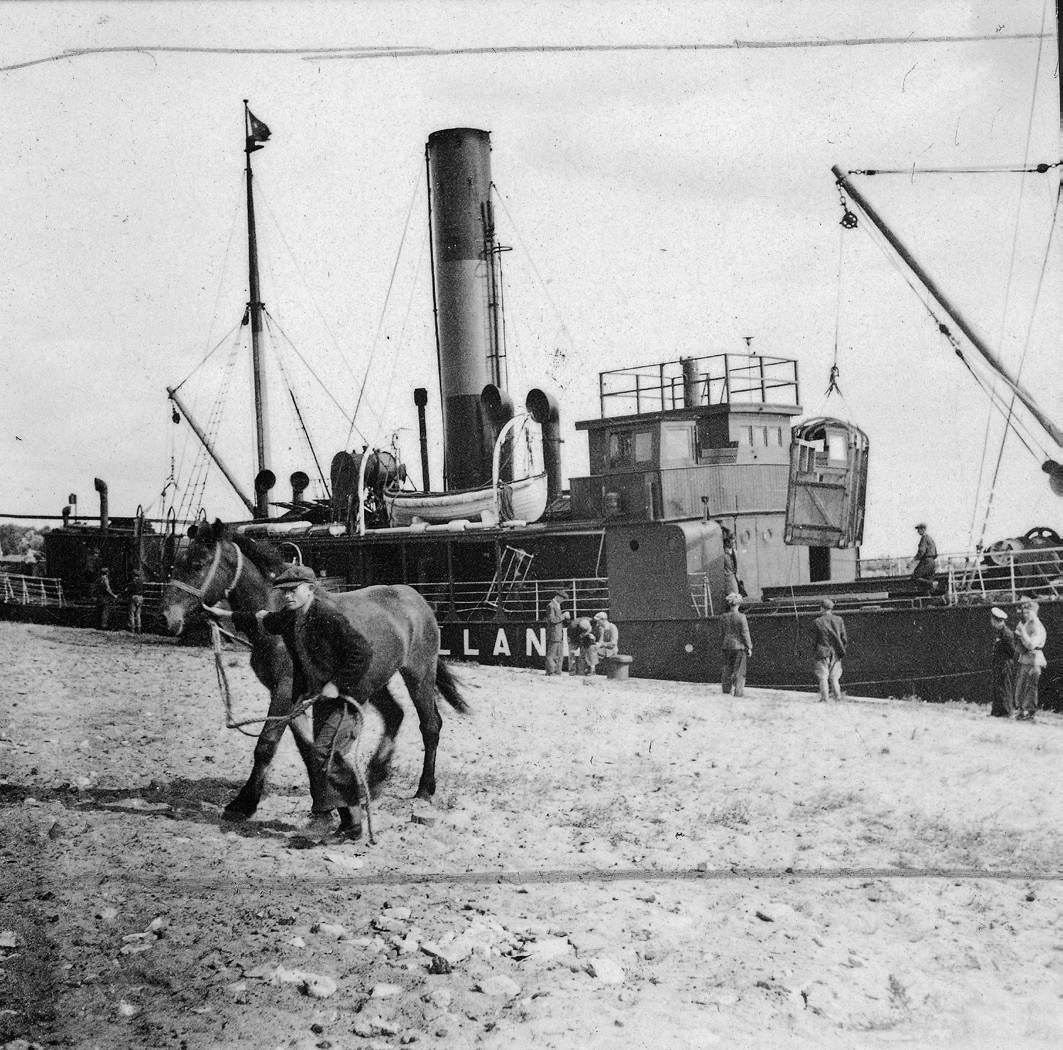 Figure 8. A man leads a horse away from a docked ship, while other men stand beside the ship looking up at the wooden crate hoisted above their heads on its way back to the ship's deck to load another horse.