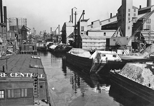 Figure 5.3. The Gowanus Canal is lined with barges and industrial plants. A large cement plant is in the foreground; in the distance is a gas works.