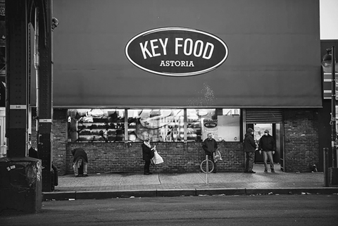Figure 11. In the early morning light in Astoria, Queens, four customers, each six feet apart, wait outside a Key Food supermarket.
