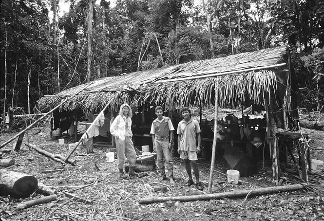 Jan Caldwell and two Brazilian colleagues stand next to the thatched shelter in their field camp in the state of Acre, western Brazil.