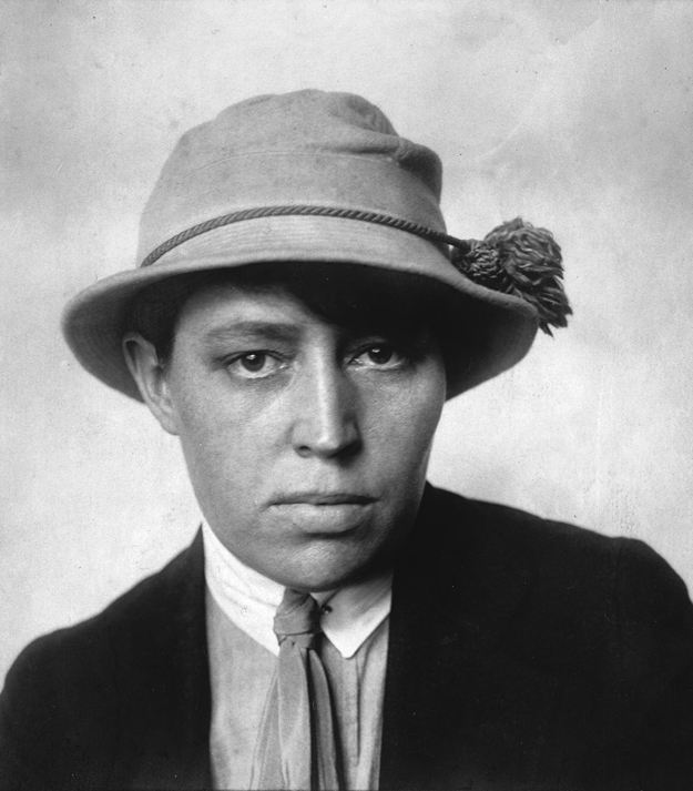 Figure 2. A young Jane Heap stares forward confidently. She wears a soft, brimmed hat, suit jacket, collared shirt, and necktie.