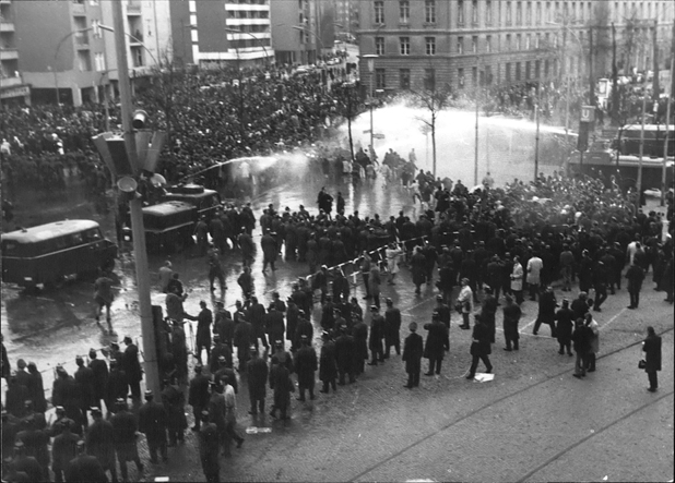 Figure 16. German police line one side of the street as they use multiple water cannons to spray water under high pressure in an attempt to disperse thousands of students protesting on the other side of the street.
