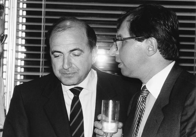 Berezovsky standing and talking with Petr Aven, who is holding a glass, 1998.