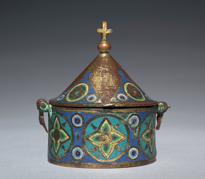 Figure 29. A round container with a cone-shaped lid decorated with green, blue, and white patterns in enamel.