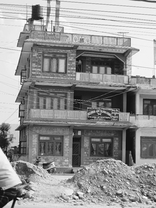 Figure 3.2. Gurkha Army Training School, Pokhara, a three-story building with large piles of dirt and sand in front.