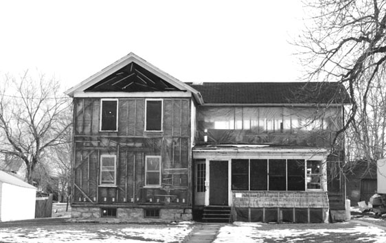 Figure 11 With its siding mostly removed, the wood framing of the Stanton house is visible through its winter covering of plastic sheeting.