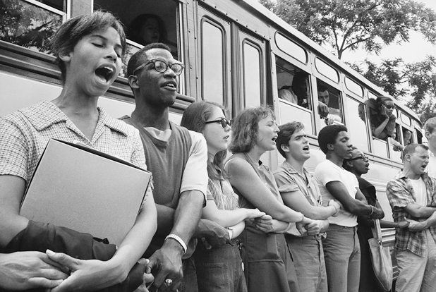Figure 4. A line of young people, some Black, some white, their arms crossed and linked with the person next to them, are singing as they complete their training sessions and prepare to head South to Mississippi.