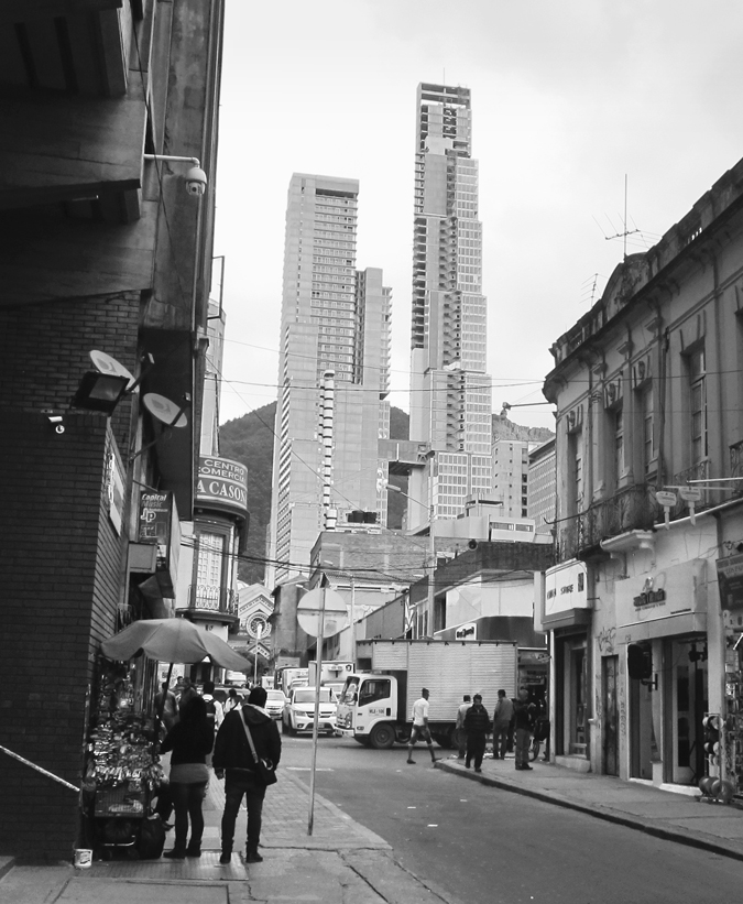 Figure 5.2A. A city street view with buildings lining the street. In the background is a large building with two towers.