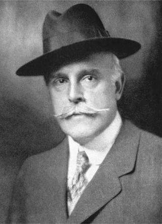 Figure 8.1. A handsome and dapper man, with Fedora hat and a gray handlebar mustache, looks confident in this portrait photograph.