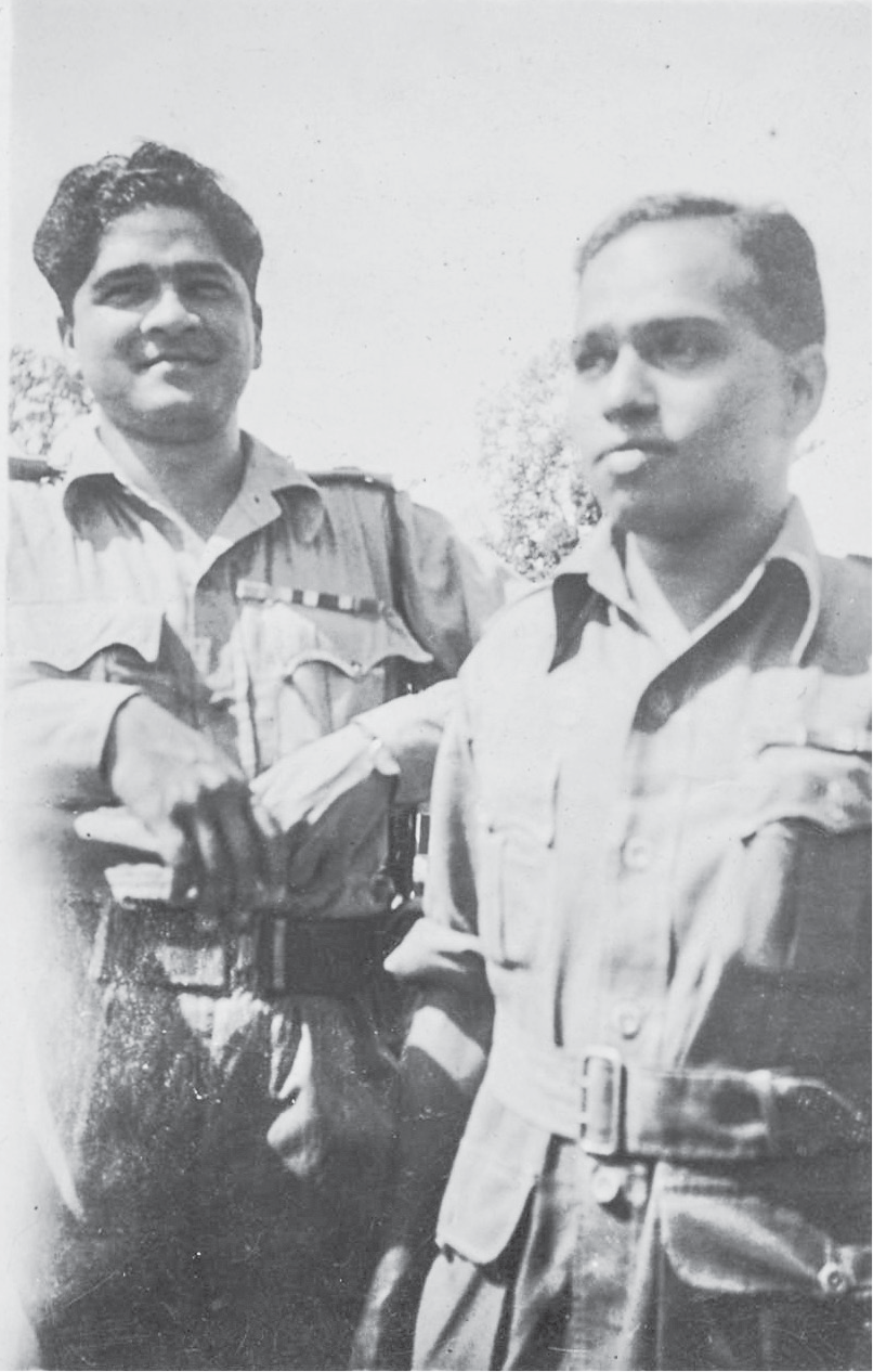 Uncle Mohan with a fellow army medic, both in their twenties and in military uniform, smile faintly as they look into the distance.