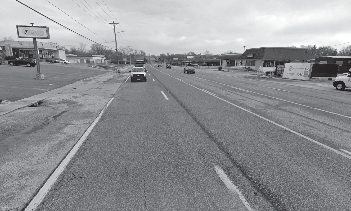 Figure 13.8: A photograph of West Florissant Avenue near Canfield Drive in Ferguson showing the barren expanse of asphalt and the absence of pedestrian amenities.