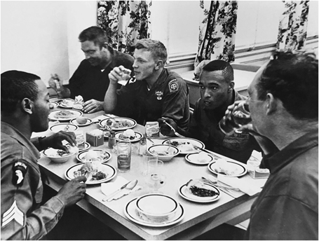 Figure 8. Five military personnel share a sit-down meal together at a dining table.