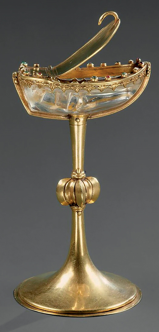 Figure 26. A saltcellar. A gold-mounted rock-crystal boat rests on a high, knopped stem, above a tapered, conical base, also in gold. The crystal boat has a pointed prow and flat transom and is covered by a hinged gold lid. On the boat’s gunwales are small seed pearls, emeralds, and balas rubies set in minute, cylindrical gold collars.