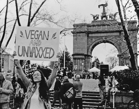 Figure 22. In a demonstration at Grand Army Plaza in Brooklyn, a protestor holds a sign reading “vegan and unvaxxed.”