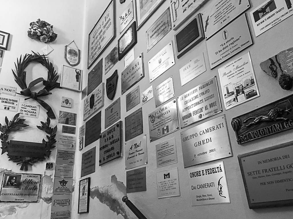 Figure 4.8. Two corner walls almost completely covered in plaques of various sizes and materials, as well as a couple of large iron laurel wreaths.