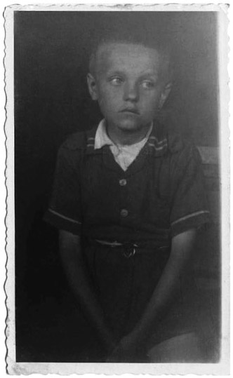 Figure 22. Photo of a young boy standing with hands folded in front.