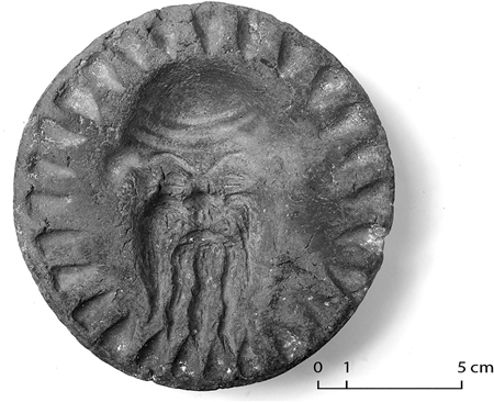 Figure 12.6. A bread stamp with Silenus indentation from Room 28 at Bi’r Samut, with scale bar.