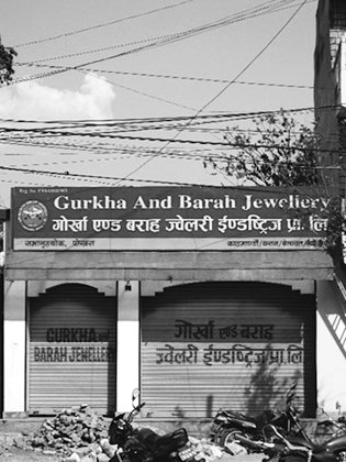 Figure 3.7. The outside signage for a Gurkha and Barah jewelry store with power lines above and two large garage doors underneath.