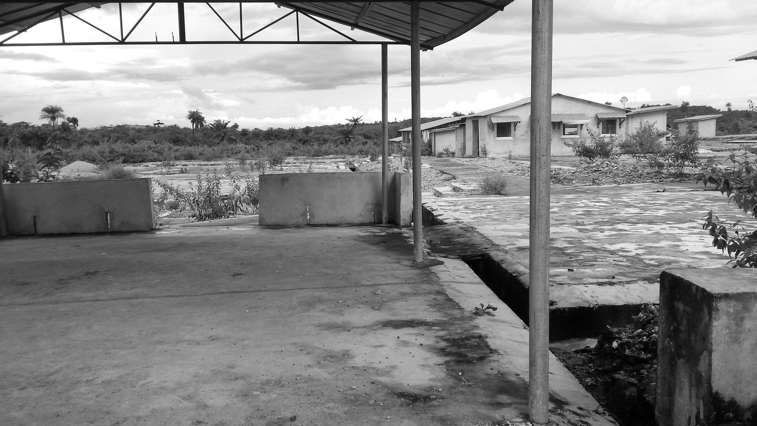 Figure 5. An empty pavilion with a tent overhead stands in the foreground. An empty field and houses are seen in the background.
