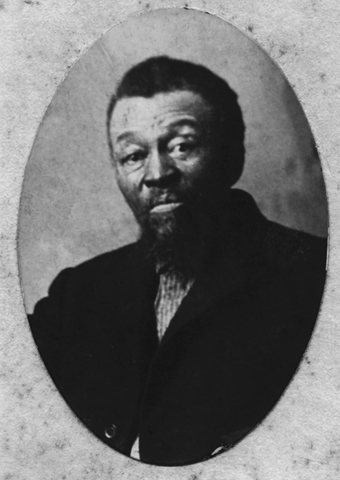 A middle-aged farmer, in plain black coat without vest or tie, looks watchful and alert. The slight lift of his eyebrows seems skeptical, or at least unimpressed.