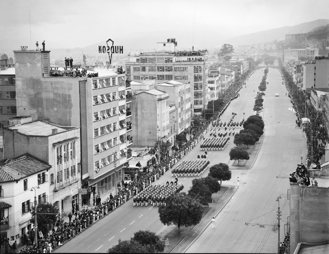 Figure 1.3. Several military groups march down a street.