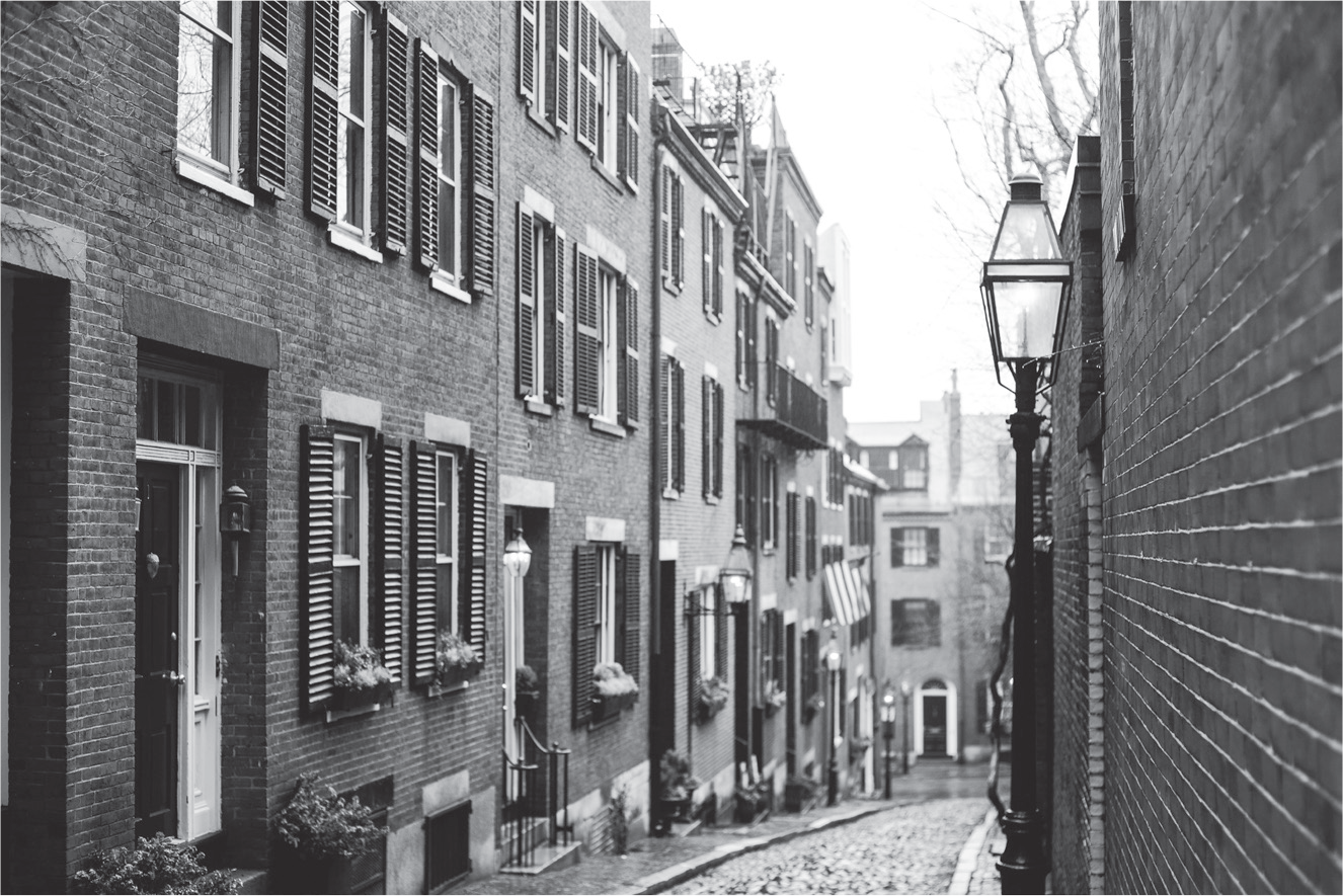 Figure 3.2: A photo of Acorn Street in Boston, a typical narrow early nineteenth-century cobblestone street with three- and four-story brick row houses.